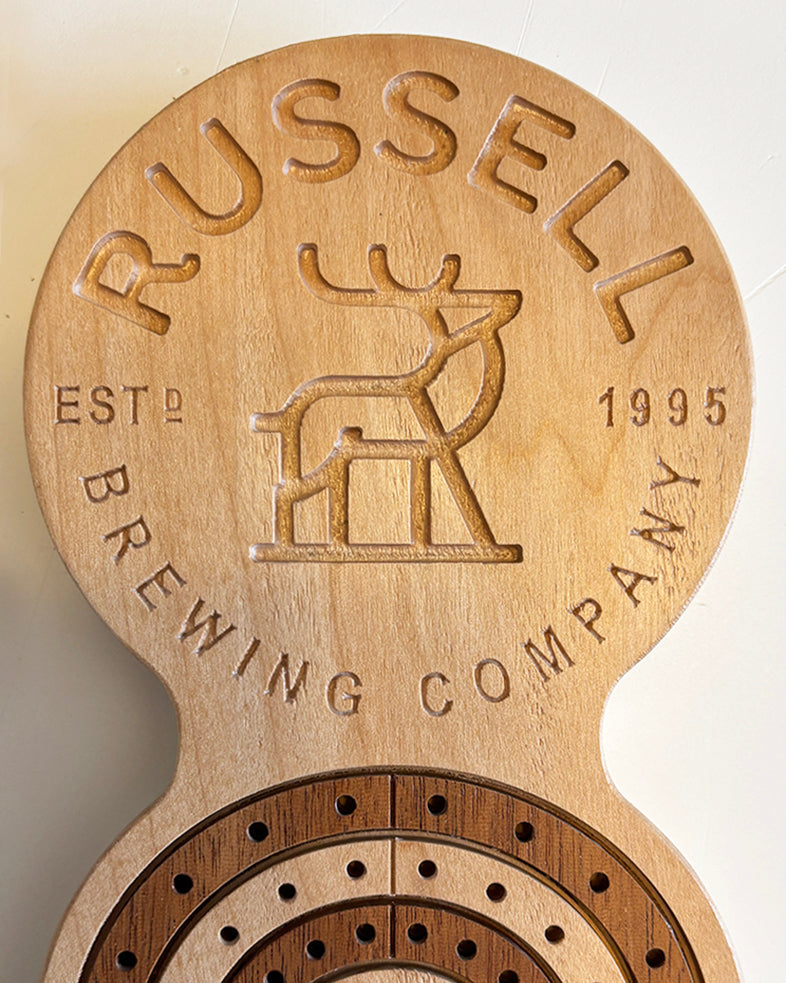 Inlayed, wooden cribbage board with custom branding.