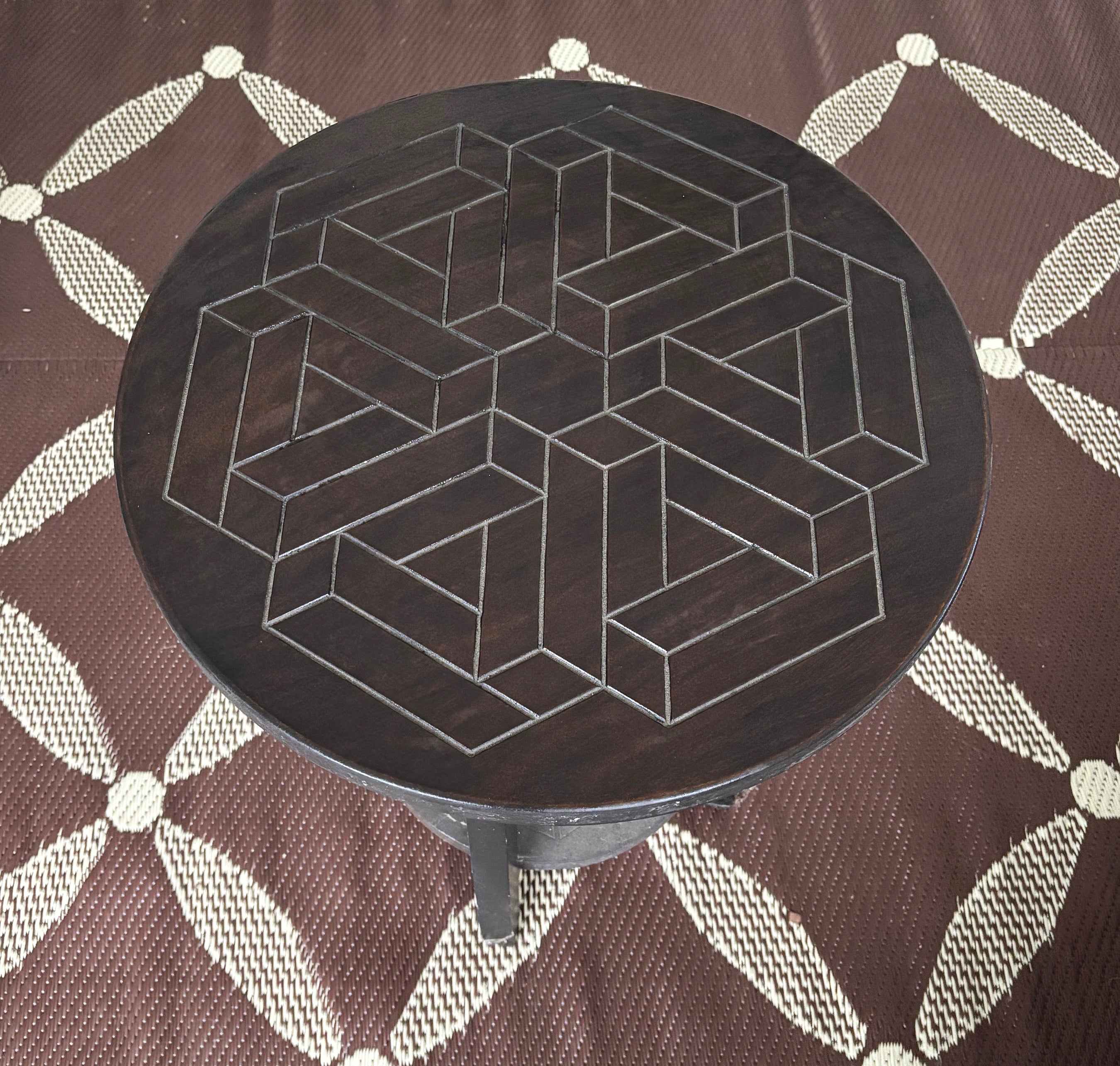 Round table with engraved geometric design.