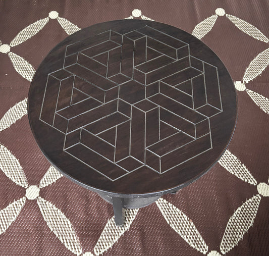 Round table with engraved geometric design.